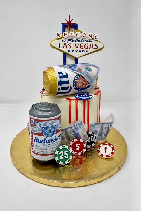 Cake with Las Vegas sign, beer cans, $100 bills, poker chips.