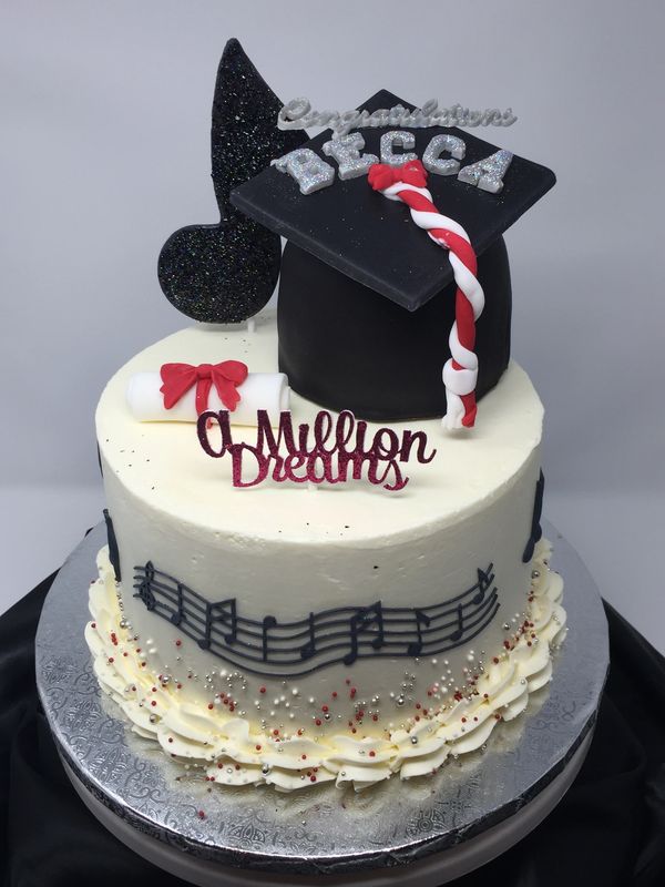 musical theme graduation cake with music notes on the side and top and graduation hat and diploma 