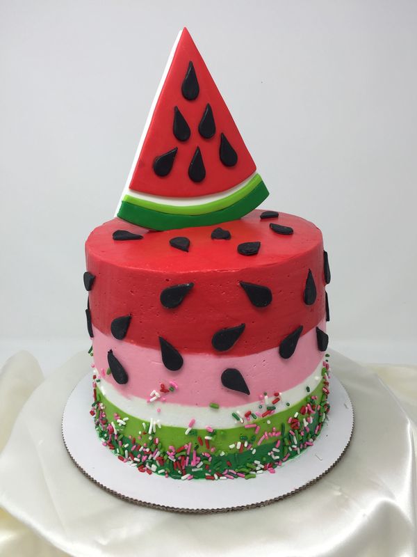 watermelon colored cake with watermelon slice on top