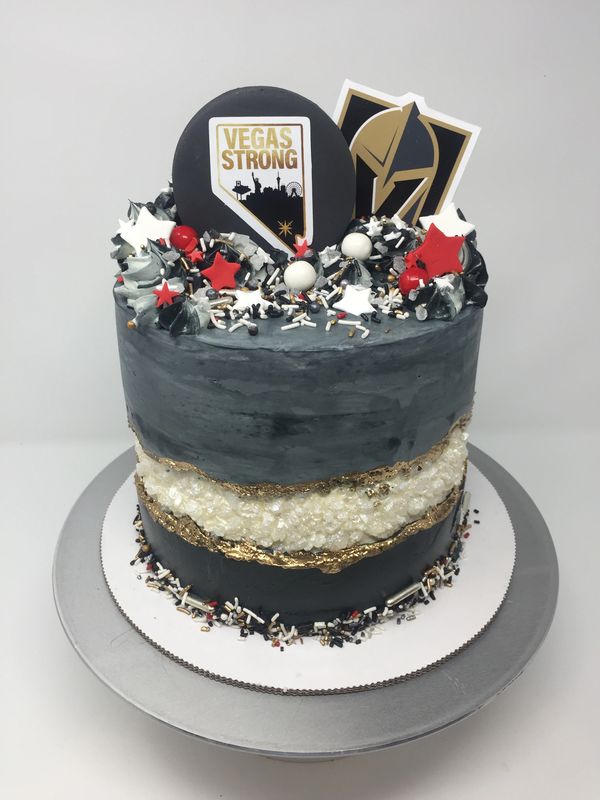 gray and black fault line cake with Vegas Strong and Vegas Golden Knights logos.