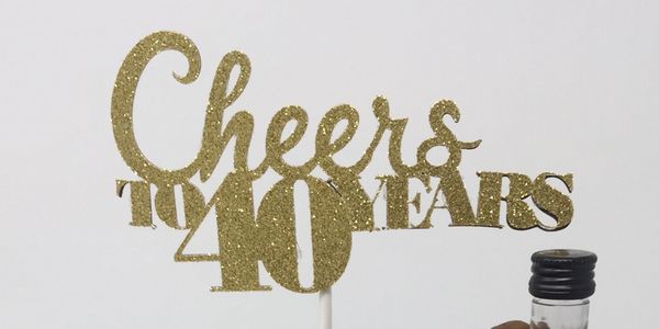 Gold cake topper that says Cheers to 40 years