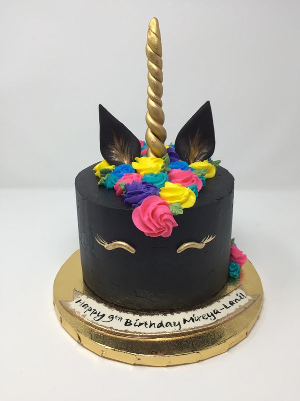 Black unicorn cake with bright color mane rosettes.
