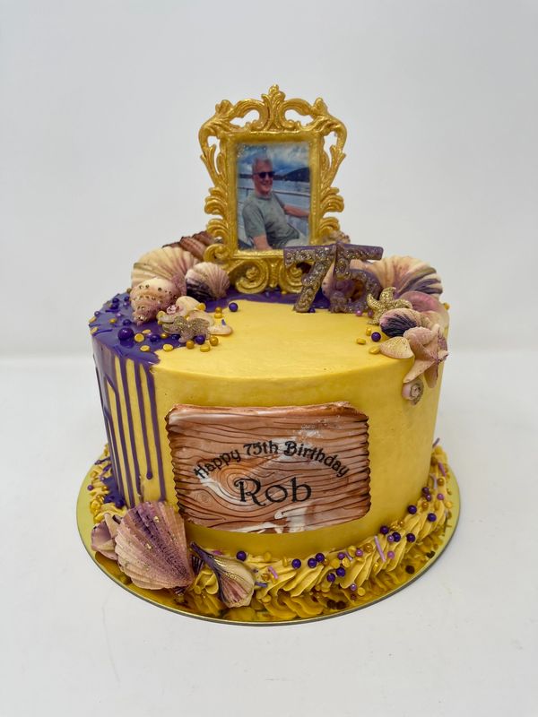 Gold cake with sea shells and purple drip.