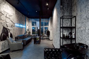 Modern lounge area with gray furniture, art, and textured walls.