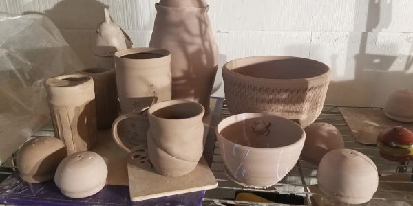 Various unglazed pottery pieces on a shelf.
