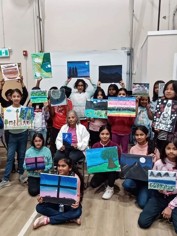 Group of children displaying their paintings.