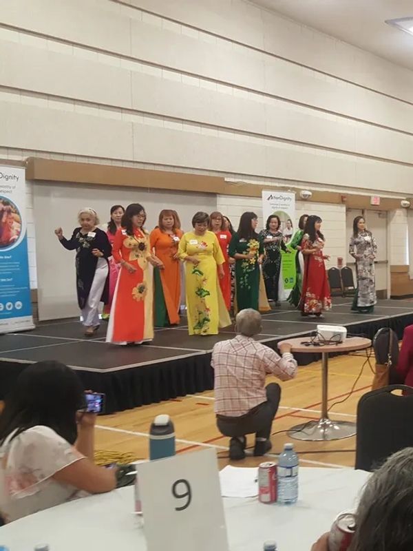 Group of women in colorful traditional dresses performing on stage.