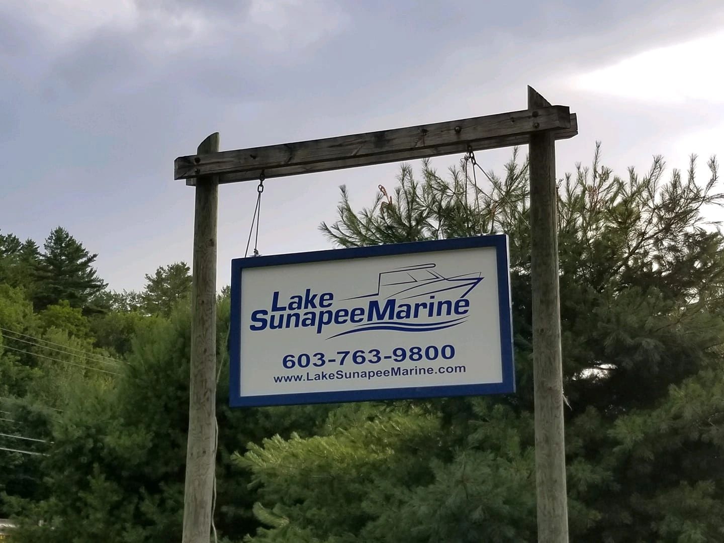 Signboard of Lake Sunapee Marine with contact details outdoors.