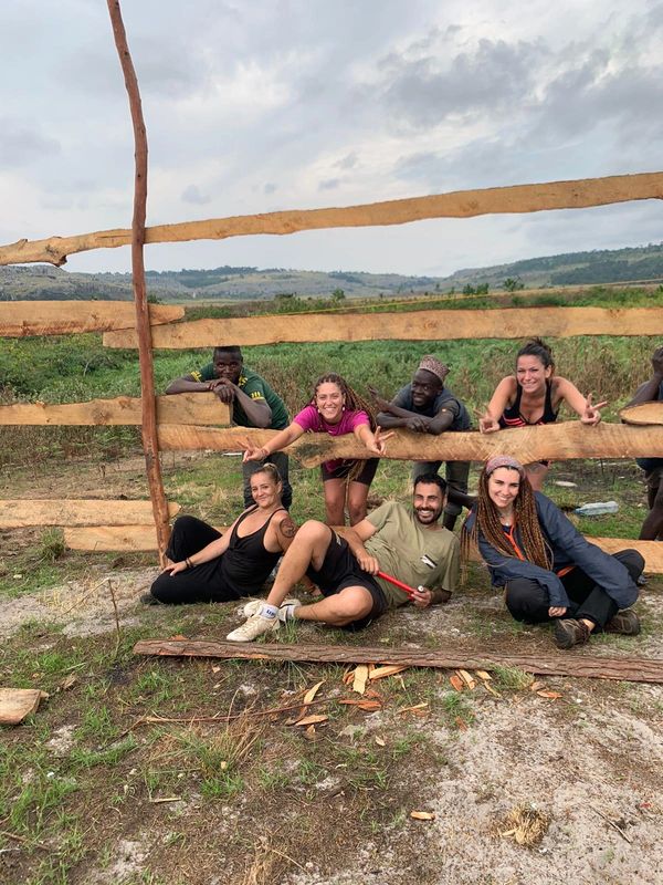 Grupo de adultos delante de una valla.