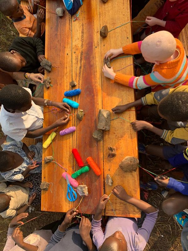 Grupo de niños realizando pulseras.