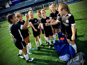 Young soccer team gathers for a motivational cheer on the field.