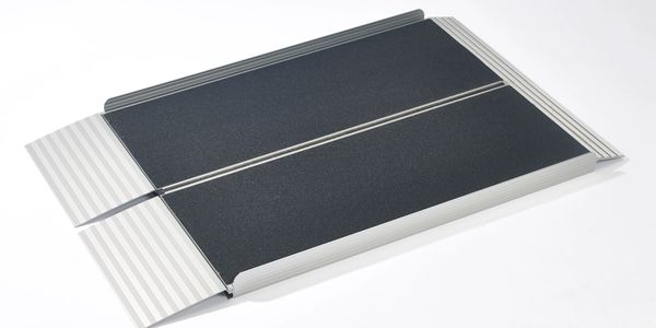 A black and silver portable folding ramp for accessibility.