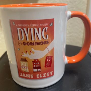coffee mug with Dying for Dominoes book cover