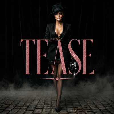 Woman in black suit and hat with 'TEASE' text in glamorous setting.