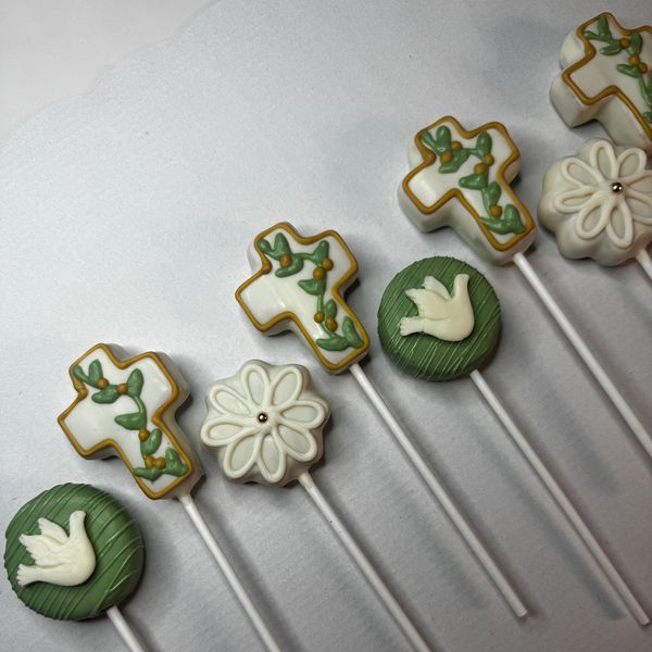 Religious-themed decorated cake pops on sticks.