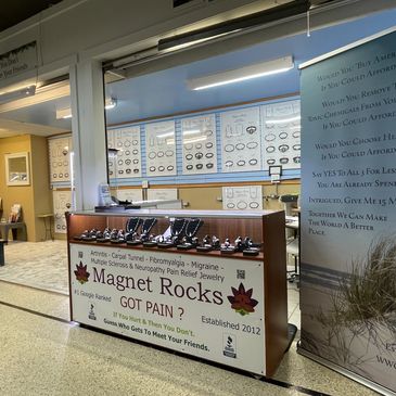 Close-up of wellness-themed magnet jewelry with informational signage.