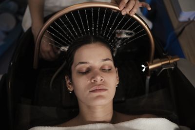 Female client receiving a head spa treatment in Plano, TX.
