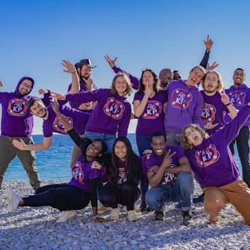 group of teenagers on a beach in team jumpers