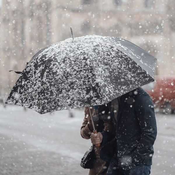 Image of person with large umbrella and the rain is pouring down