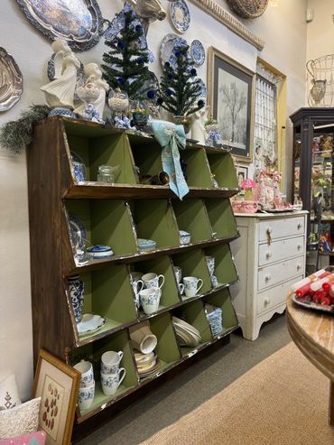 Vintage shelf with blue and white china and holiday decorations in a cozy antique shop.