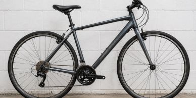 Sleek black bicycle against white wall.