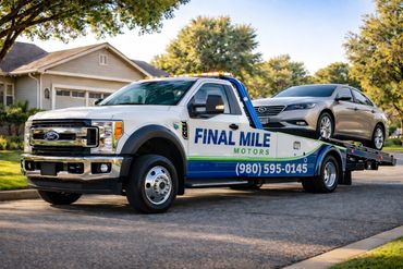 Final Mile Motors tow truck transporting a car in a residential neighborhood.