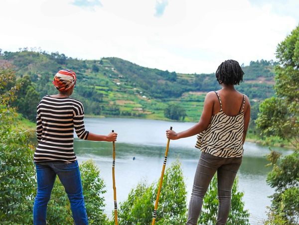 Two ladies hiking with view of Lake Bunyonyi