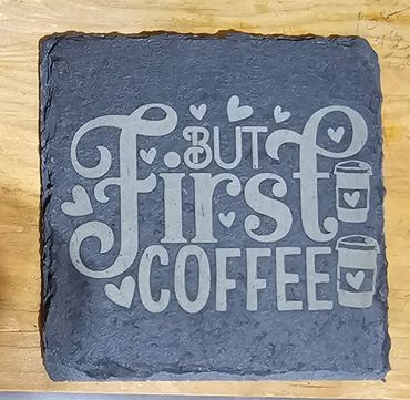 Slate plaque with the phrase 'But First Coffee' and heart decorations.