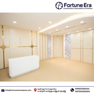 Modern minimalistic interior with white and gold accents and a sleek white reception desk.