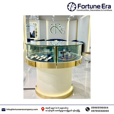 Elegant circular glass display case showcasing jewelry in a modern store setting.