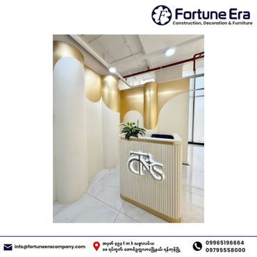 Modern reception area with white and gold decor and illuminated logo.
