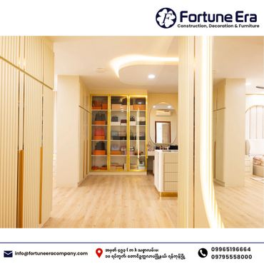 Modern, elegant walk-in closet with glass display cabinets and warm lighting.
