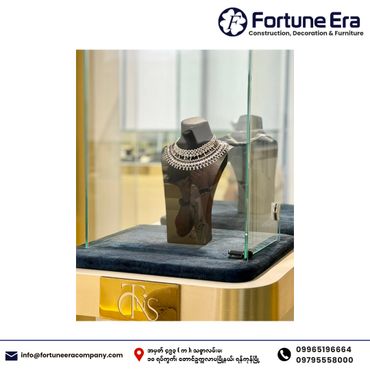 Elegant diamond necklace displayed in a glass case on a velvet cushion.