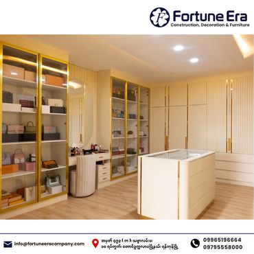 Modern luxury walk-in closet with glass cabinets and gold accents.