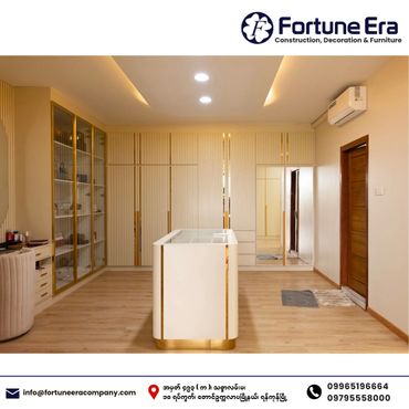 Modern walk-in closet with sleek white and gold cabinetry and central island.