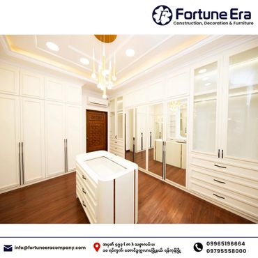 Elegant white walk-in closet with wooden flooring and modern lighting.