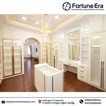 Luxurious walk-in closet with white cabinetry and elegant lighting.
