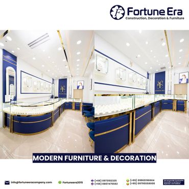 Elegant jewelry showroom with modern blue and gold display counters and bright lighting.