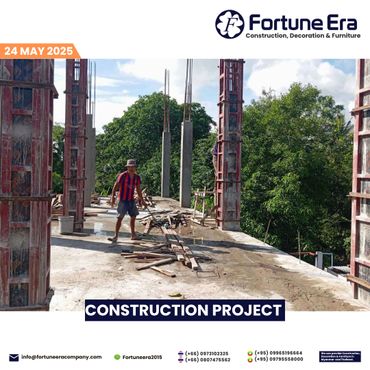 Construction worker on site with concrete columns and wooden planks under sunny sky.
