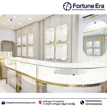 Modern, elegant display counters with glass tops and gold accents in a bright showroom.