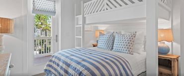 Cozy bedroom with blue striped bedding and sailboat-themed pillows.
