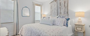 Cozy bedroom with floral bedding and rustic wooden headboard.
