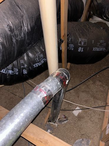 Metal ductwork and insulation in an attic.