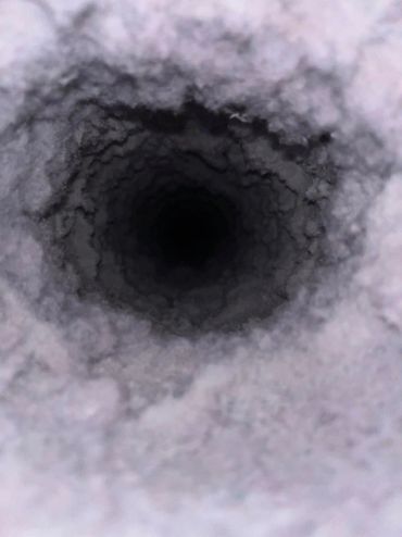 Close-up of a dark, fuzzy tunnel or hole.