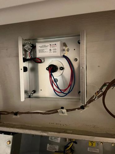 Open electrical box with wiring and power supply.