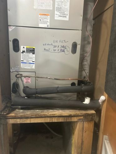 Air conditioning unit with handwritten filter size notes.