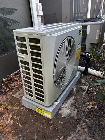 Outdoor HVAC unit installed on concrete base.