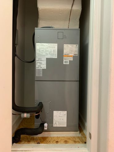 Gray HVAC unit installed in a small closet space.
