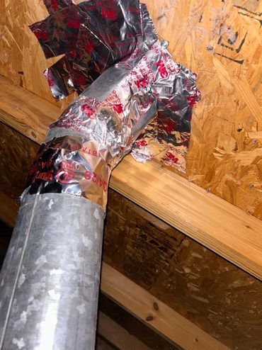 Duct taped metal vent pipe in attic.