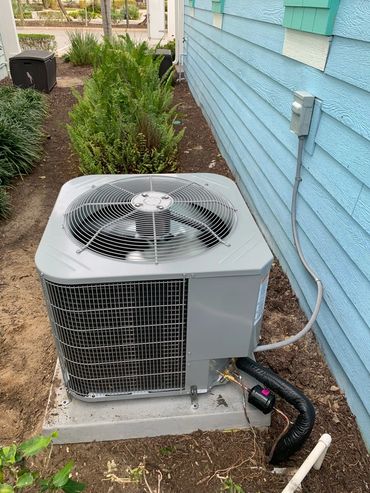 Outdoor air conditioning unit next to a house.